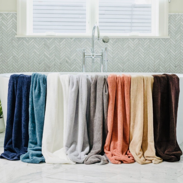 Colorful towels hanging on a towel rack in a bathroom.